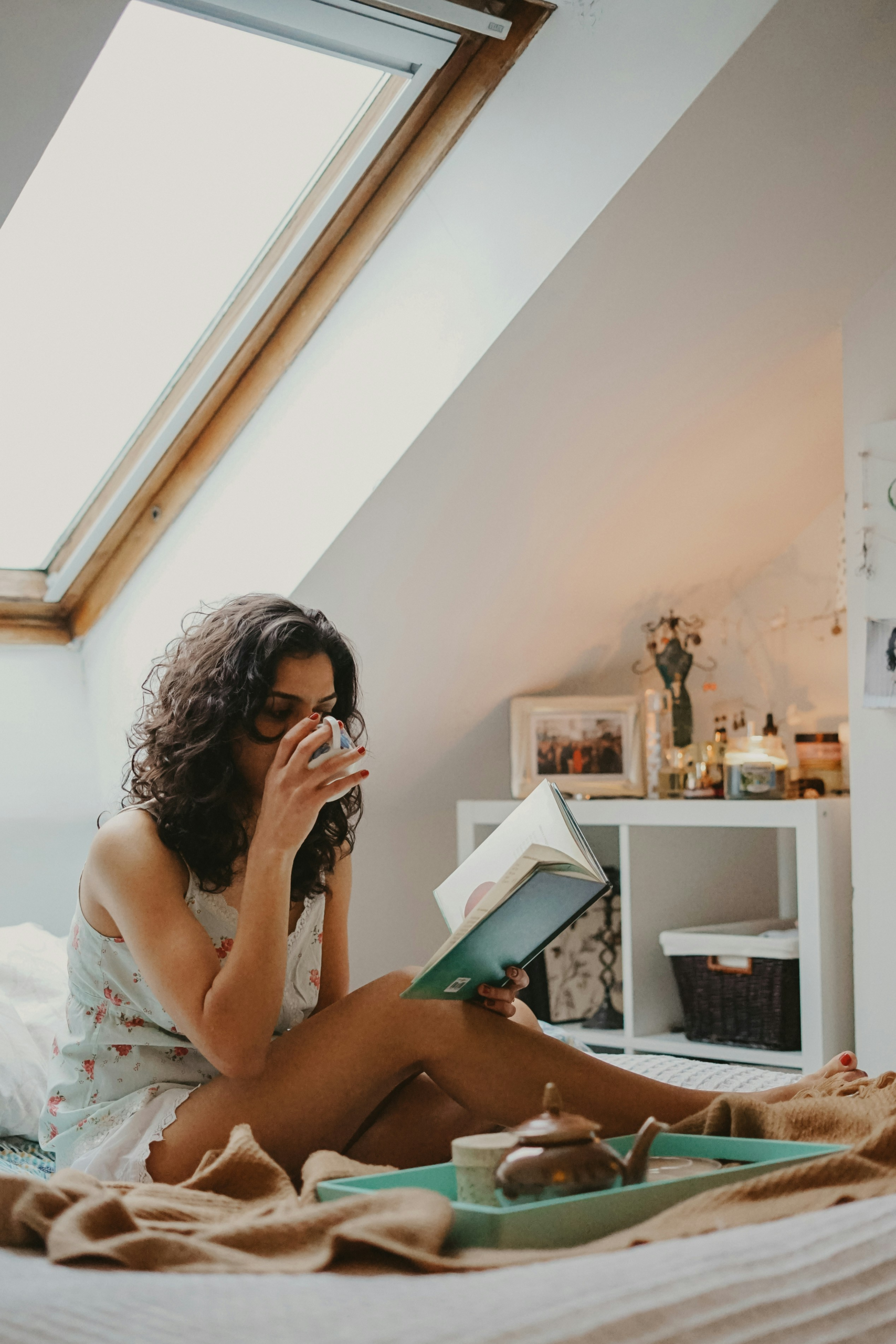 Femme qui lit un livre avec un café le matin